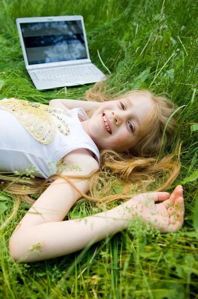 Sorridente bambina con computer portatile fuori — Foto Stock