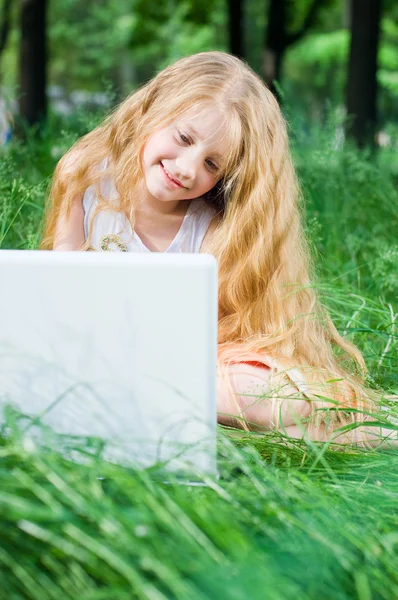 Ernst aussehendes kleines Mädchen mit Laptop — Stockfoto
