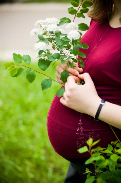 Анонимная беременная женщина с цветами — стоковое фото