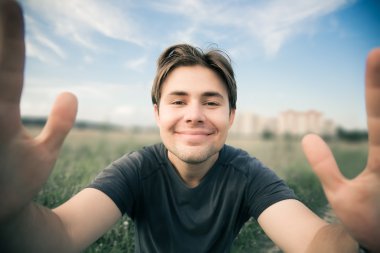 Young happy man stretching to the camera clipart