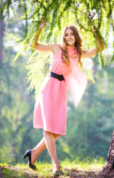 Jonge gelukkig vrouw in roze jurk — Stockfoto