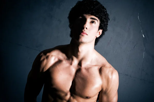 Junger muskulöser Mann auf Wandhintergrund — Stockfoto