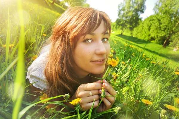 Ung kvinna som ligger på gräs — Stockfoto