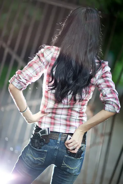 Молода жінка зі зброєю вид збоку — стокове фото