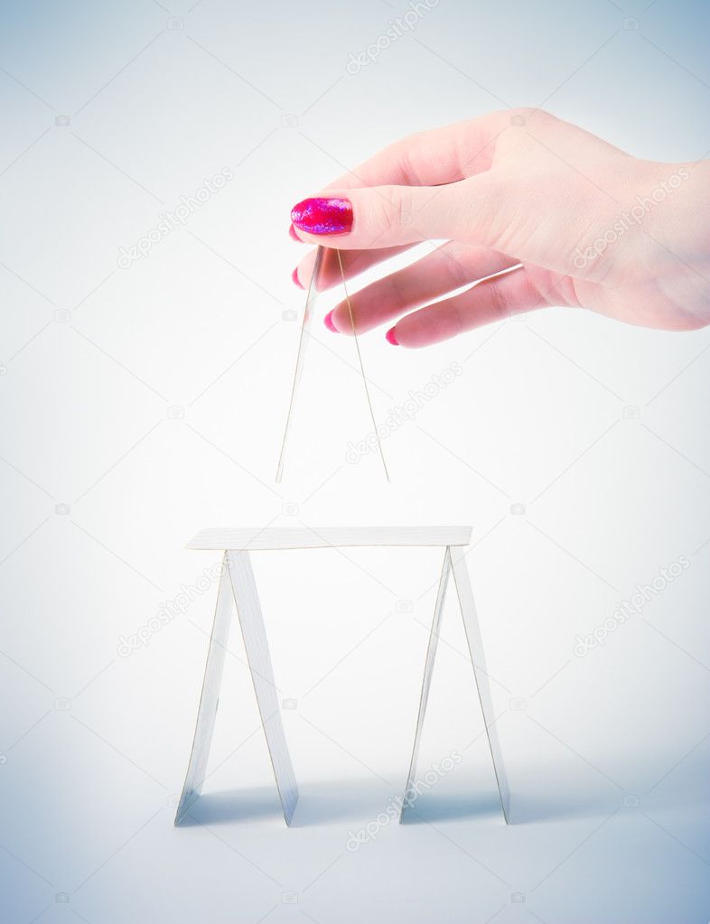 Woman hand building house from playing c