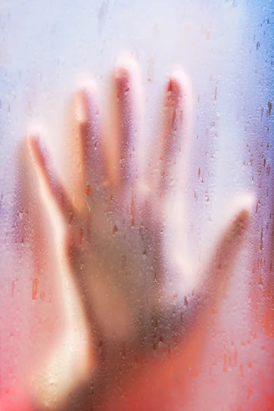 Young woman hand on translucent glass — Stock Photo, Image