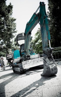 Excavator in a city clipart