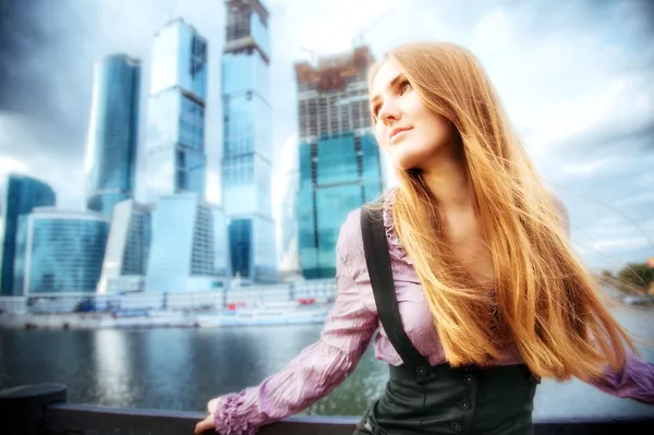 Ung kvinna på modern stad bakgrund — Stockfoto