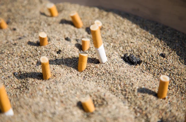 Cigarety v písku — Stock fotografie