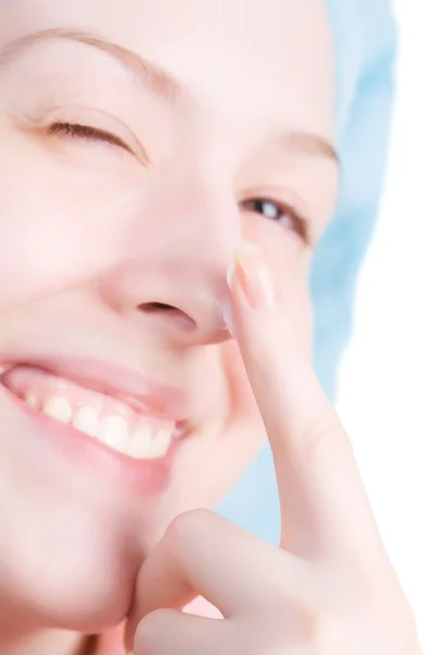 Młoda kobieta uśmiechający się kremem na nos — Zdjęcie stockowe