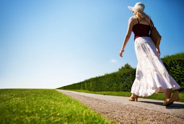 Jeune femme marchant vite sur une route — Photo