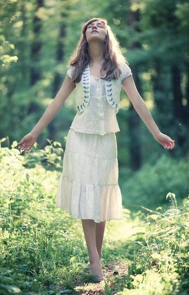 Νεαρή γυναίκα το περπάτημα σε ένα δάσος — Φωτογραφία Αρχείου