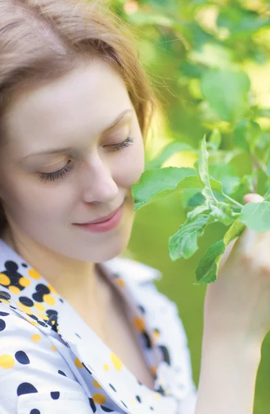 Junge Frau berührt Pflanze — Stockfoto
