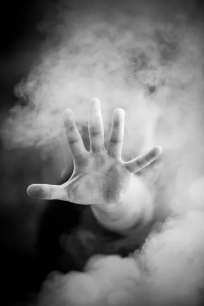 Άνθρωπος που εκτείνεται το χέρι μέσω του καπνού — Φωτογραφία Αρχείου
