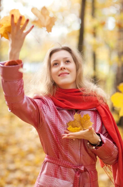 Młoda kobieta rzucając liści — Zdjęcie stockowe