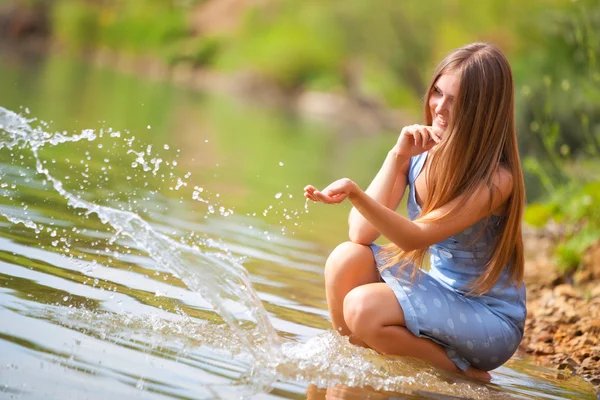 Jonge vrouw spelen met water — Stockfoto