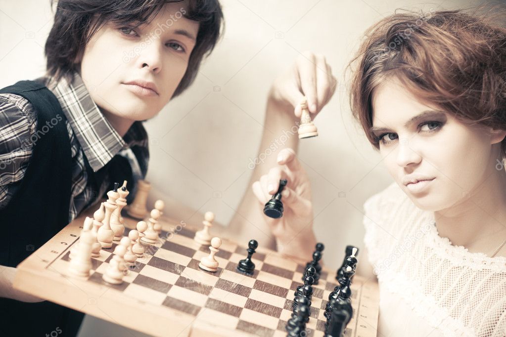 Young man and woman playing chess