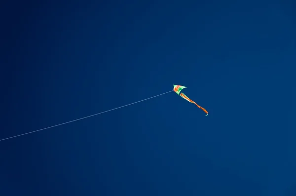 Воздушный змей на темно-синем фоне неба — стоковое фото