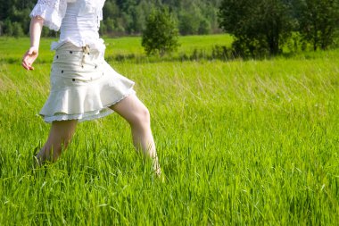 Girl walking on a field clipart