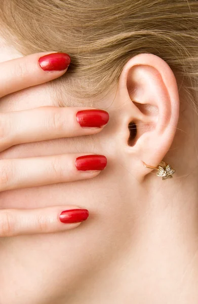 Dedos da mulher vermelha e orelha — Fotografia de Stock