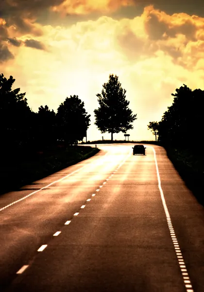 Дорога с одинокой машиной — стоковое фото
