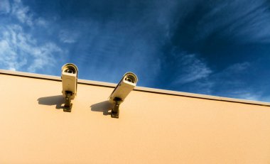 Security video cameras on a wall clipart