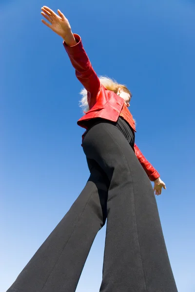 Balanceamento menina no fundo céu azul — Fotografia de Stock