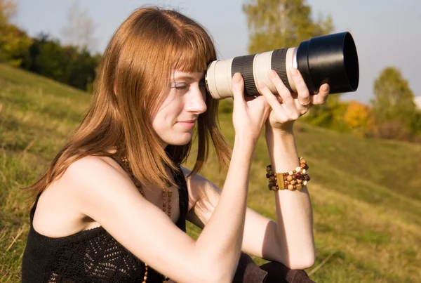 Dívka hledá ve fotoaparátu objektivem — Stock fotografie