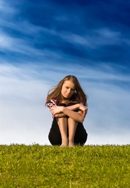 Fiatal nő ül a fűben — Stock Fotó