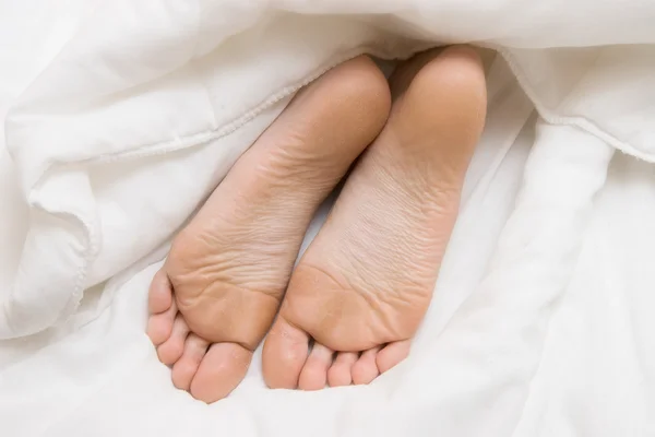 Жінка ноги на білому аркуші — стокове фото