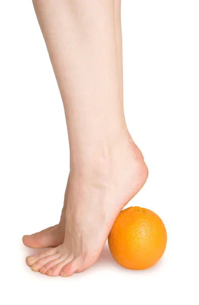 Елегантна жінка ноги над апельсином — стокове фото