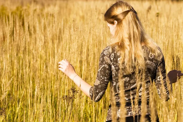 Young woman walking in a field — Stock Photo, Image