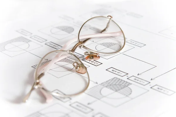 Óculos finos em um fundo gráfico — Fotografia de Stock