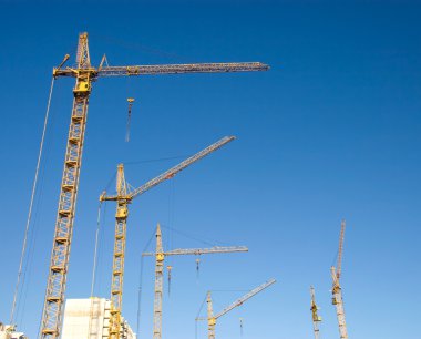 Lifting cranes on a big building clipart