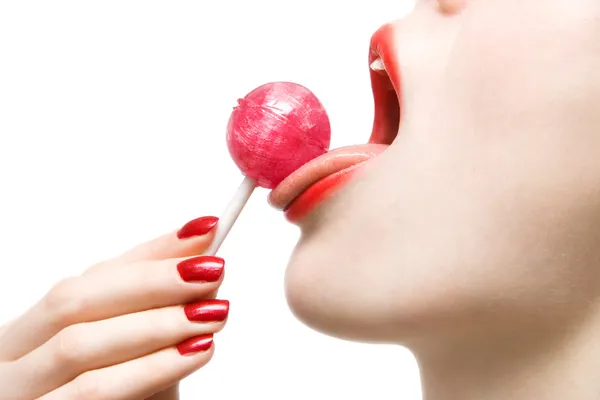 Woman licking sweet sugar candy closeup — Zdjęcie stockowe