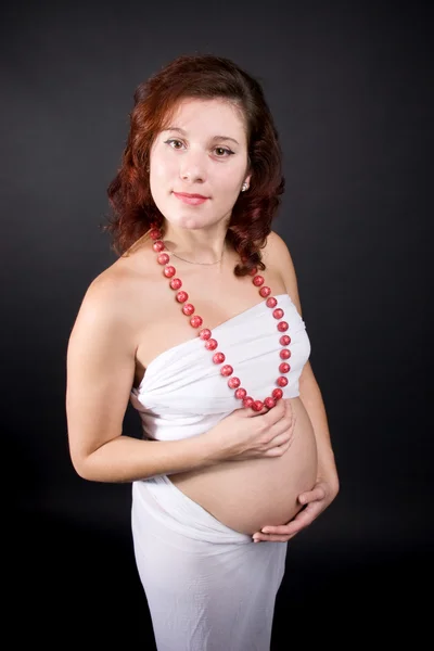 Zwangere vrouw op donkere achtergrond — Stockfoto