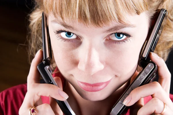 Kvinnan talar på två mobiltelefoner — Stockfoto