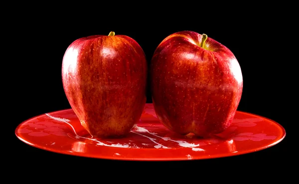 Dwóch czerwonych jabłek na czerwony talerz — Zdjęcie stockowe
