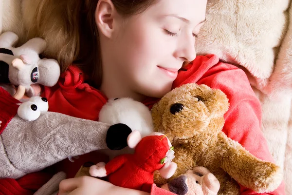 Joven tierna chica durmiendo con sus juguetes — Foto de Stock