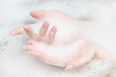 kadın bir banyoda köpüklü eller