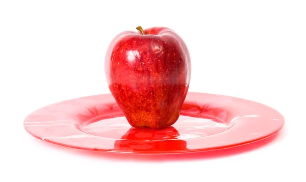 Czerwone jabłko na czerwony talerz — Zdjęcie stockowe