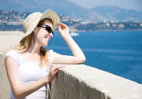Jeune femme en chapeau regardant la mer — Photo