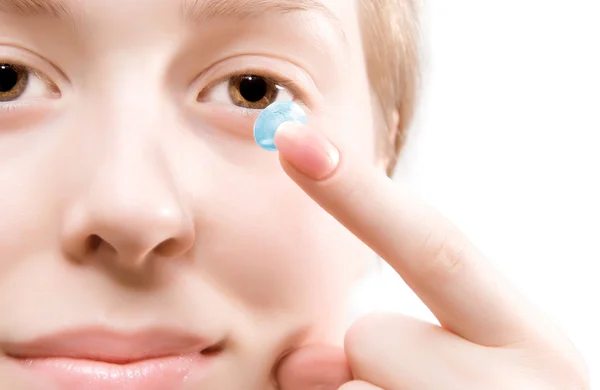 Jovem mulher colocando lente de contato azul — Fotografia de Stock