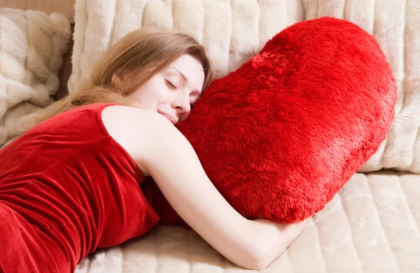 Ung kvinna som sover på röd kudde — Stockfoto
