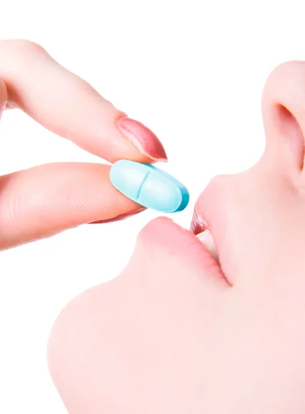 Young woman taking big blue pill — Stock Photo, Image