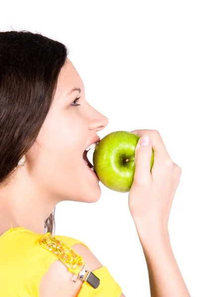 Молодая женщина кусает зеленое яблоко — стоковое фото