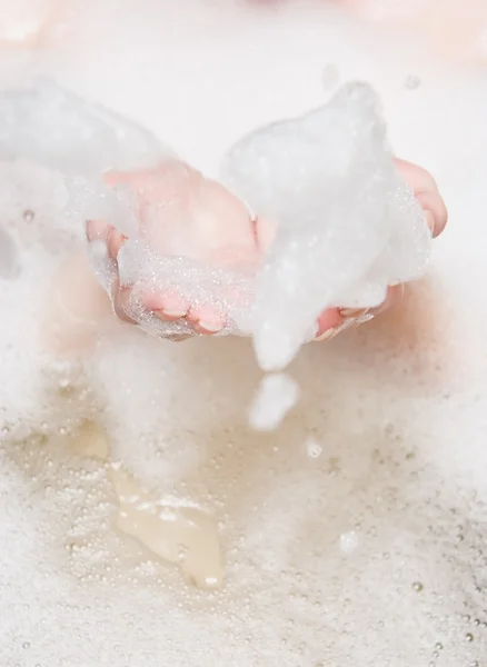 Woman in a bath blowing foam — Stock Photo, Image
