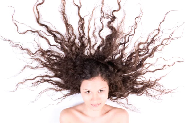 Žena s dlouhou bruneta vlasy na bílém pozadí — Stock fotografie