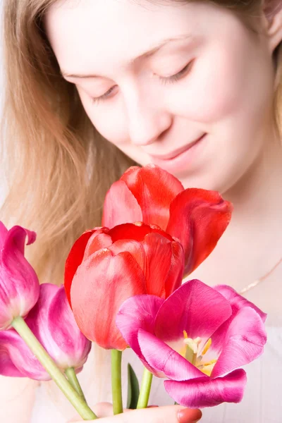 Νεαρή γυναίκα που μυρίζει λουλούδια — Φωτογραφία Αρχείου
