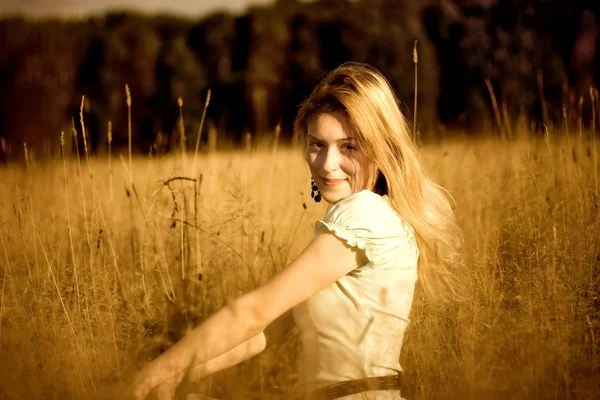 Jovem mulher na grama alta — Fotografia de Stock